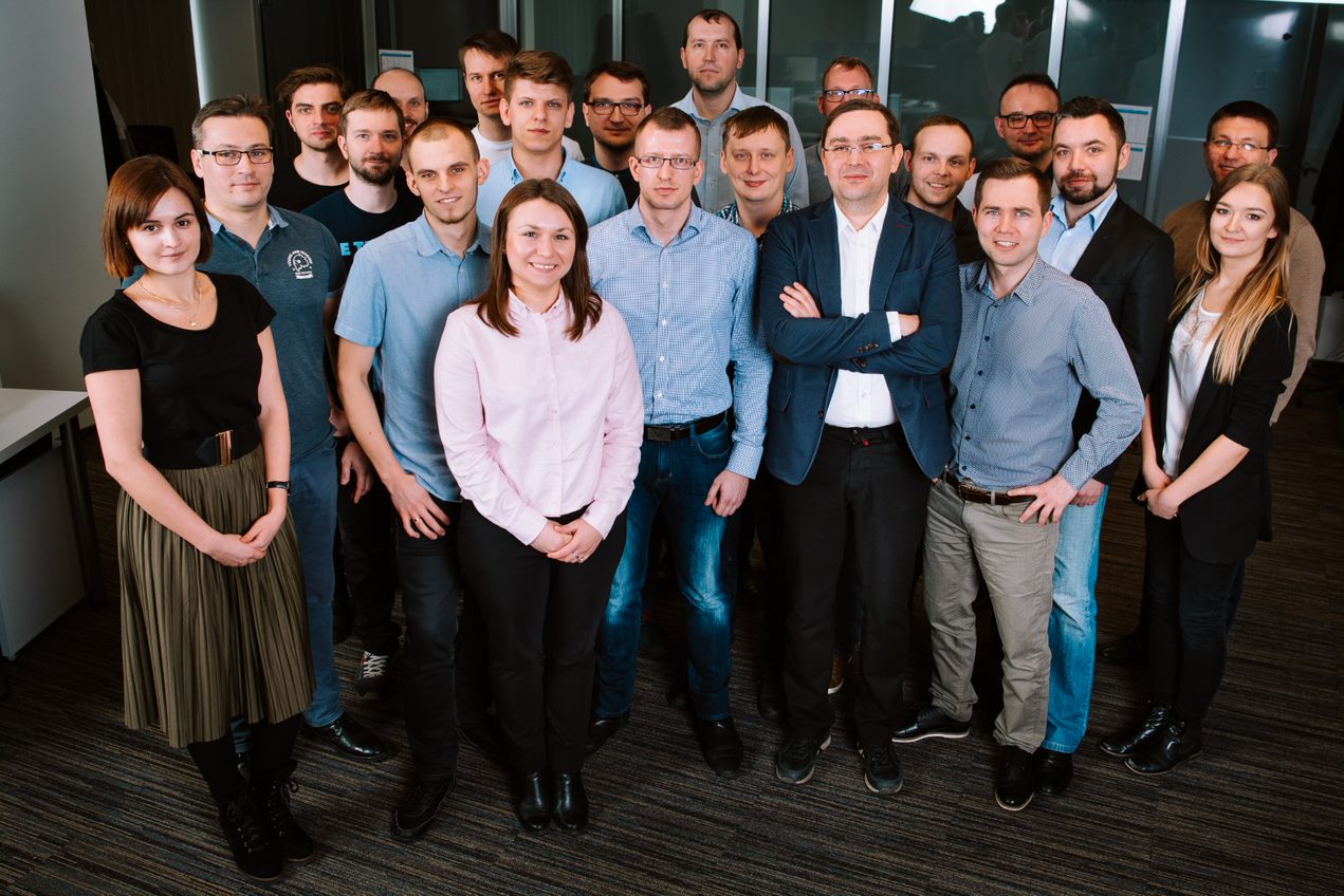 Group photo of the Spyrosoft team in 2017, featuring diverse employees standing together in an office setting.