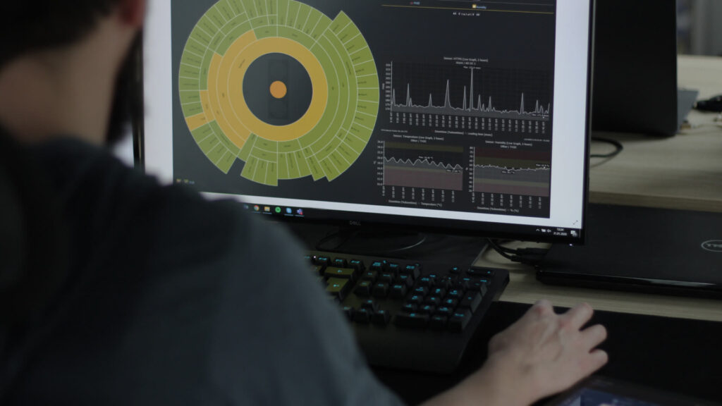 programmer looking at a computer screen with dashboards of managed services