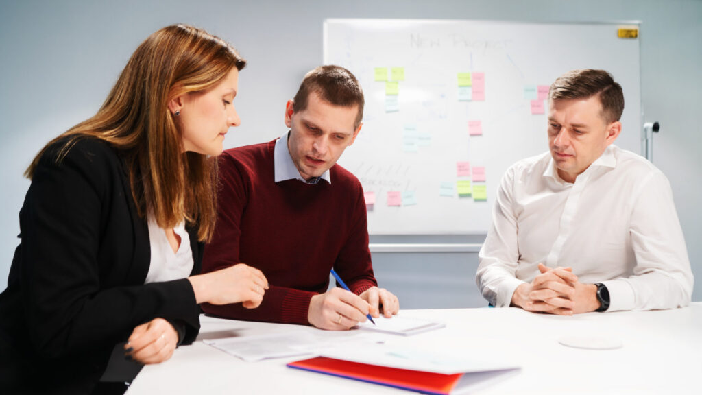 Three colleagues discussing a new project plan in a meeting room