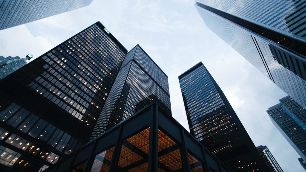 Towering glass skyscrapers seen from below, symbolizing the enterprise scale of the fintech industry where TakTo implemented AWS cloud solutions to achieve greater business flexibility