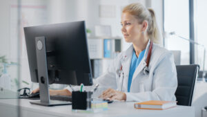 Medical professional working an a computer. Fhir explained a healthcare data standard tailored to our times