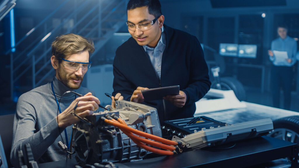Engineers working on an electric vehicle motor in a high-tech lab