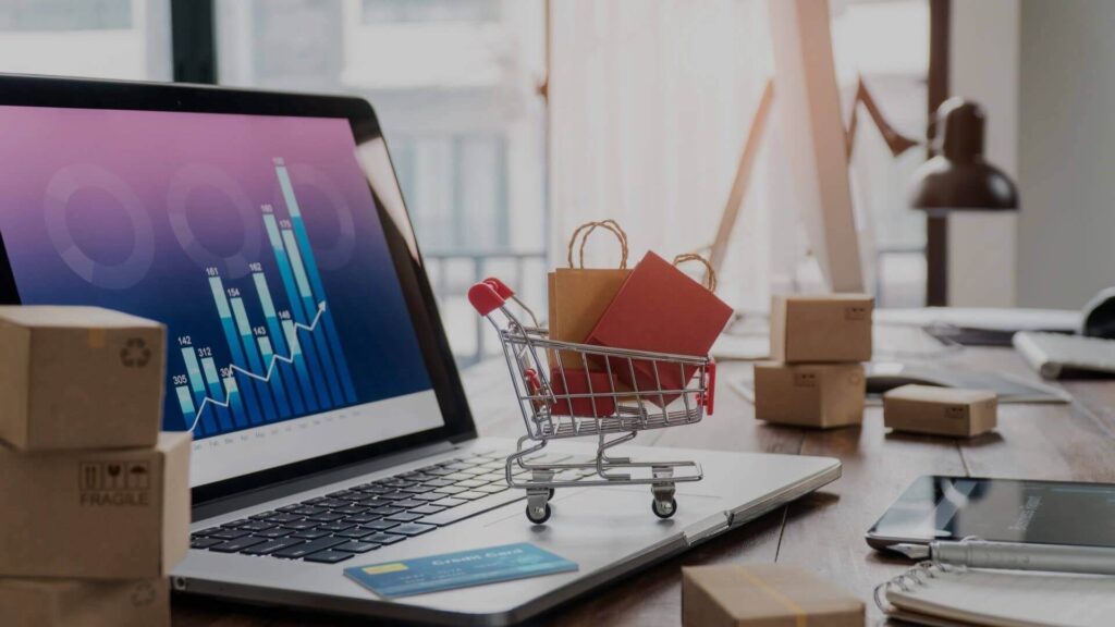 A laptop with a symbolic shopping cart on top. How to increase ecommerce conversion rate in your businesses