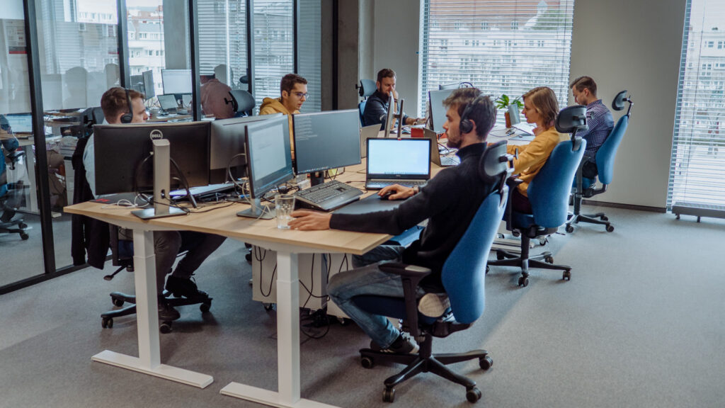 Software developers working in a bright, modern open-plan office space.