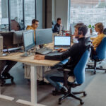 Software developers working in a bright, modern open-plan office space.