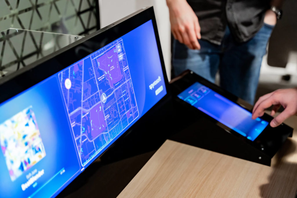 Hands touching the screen of Wavey: a gesture-controlled in-vehicle infotainment system created by Spyrosoft's HMI team in the Dojo framework.