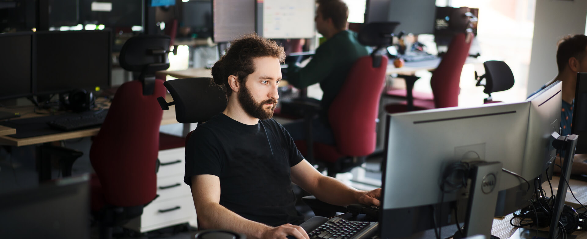 An IT developer from Spyrosoft working on two monitors.