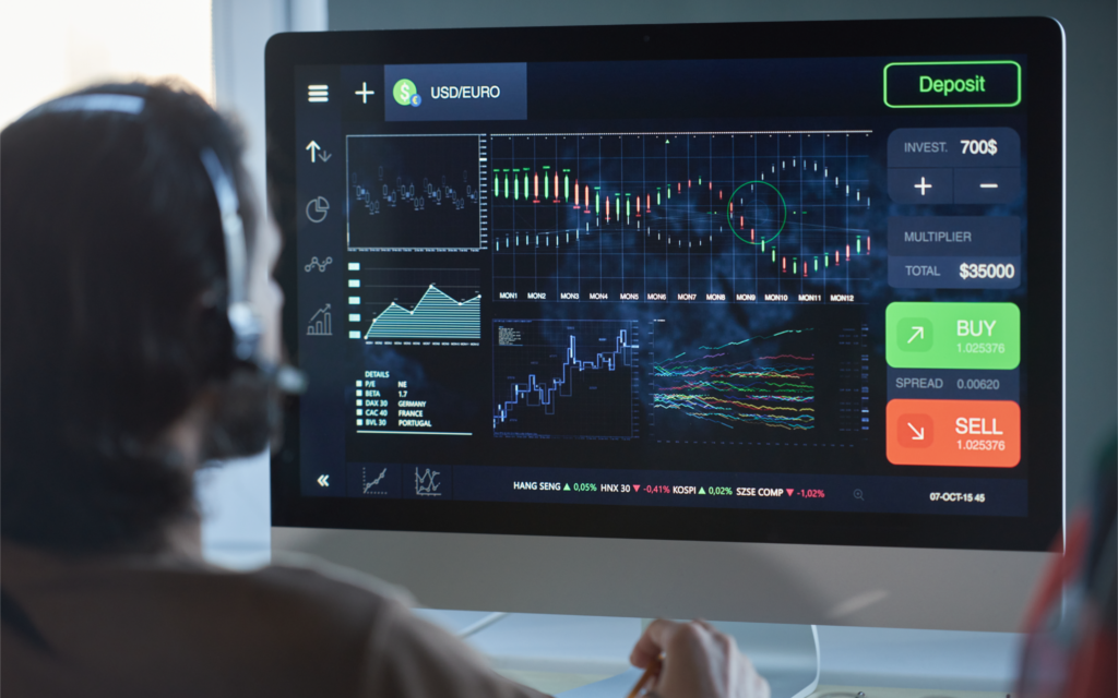A financial systems specialist looks at charts on a screen.