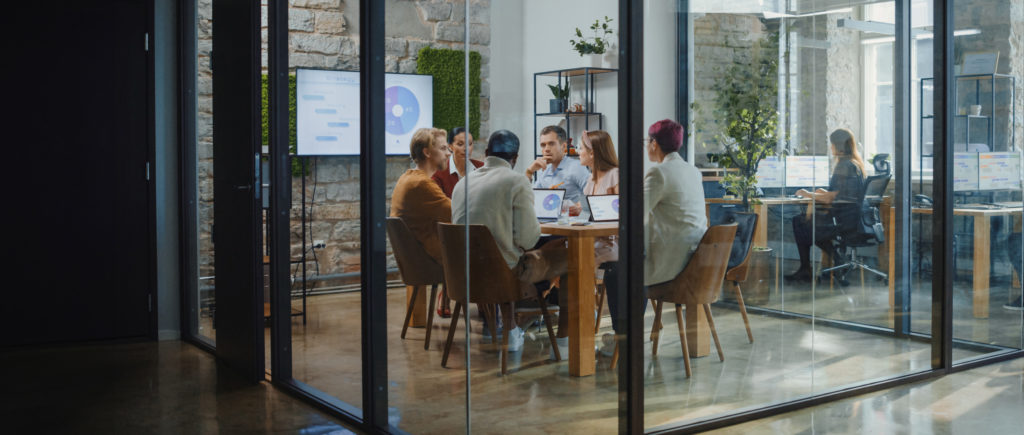 People in a glass conference room during a consulting process.