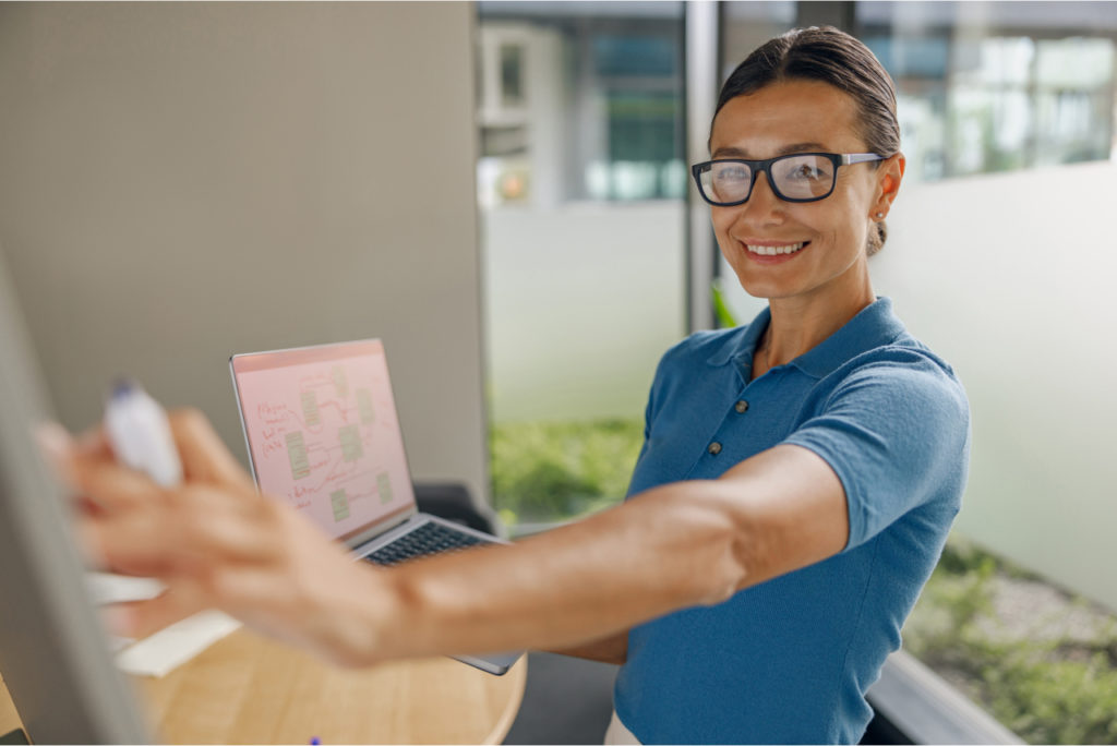 photo of a woman smiling and conducting agile consulting and coaching in an office conference room