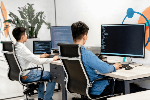 Developers working on computer screens – technical support and maintenance in OTT Managed Services