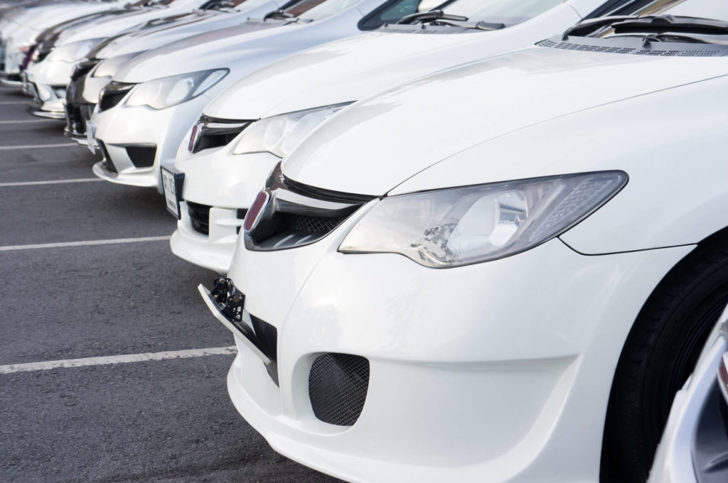 row of modern white cars parked on the parking lot