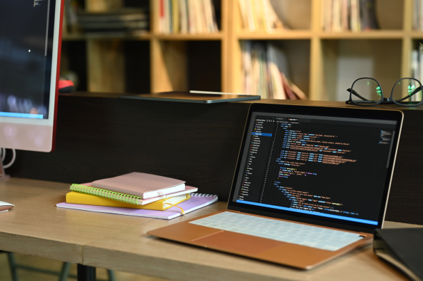 Open laptop with front-end code on desk – interface design for Connected TV App Framework