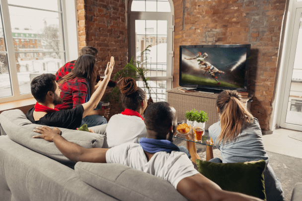 a group of people watching tv and laughing, broadcasters