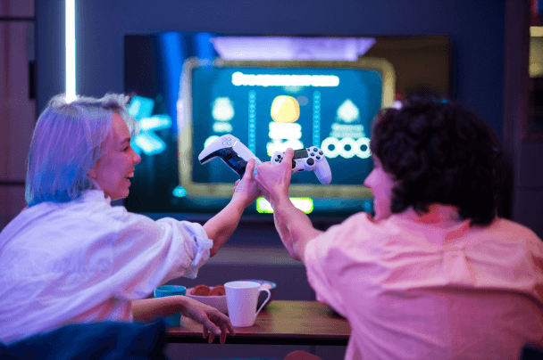 Friends playing console game together – entertainment features powered by iGaming software development