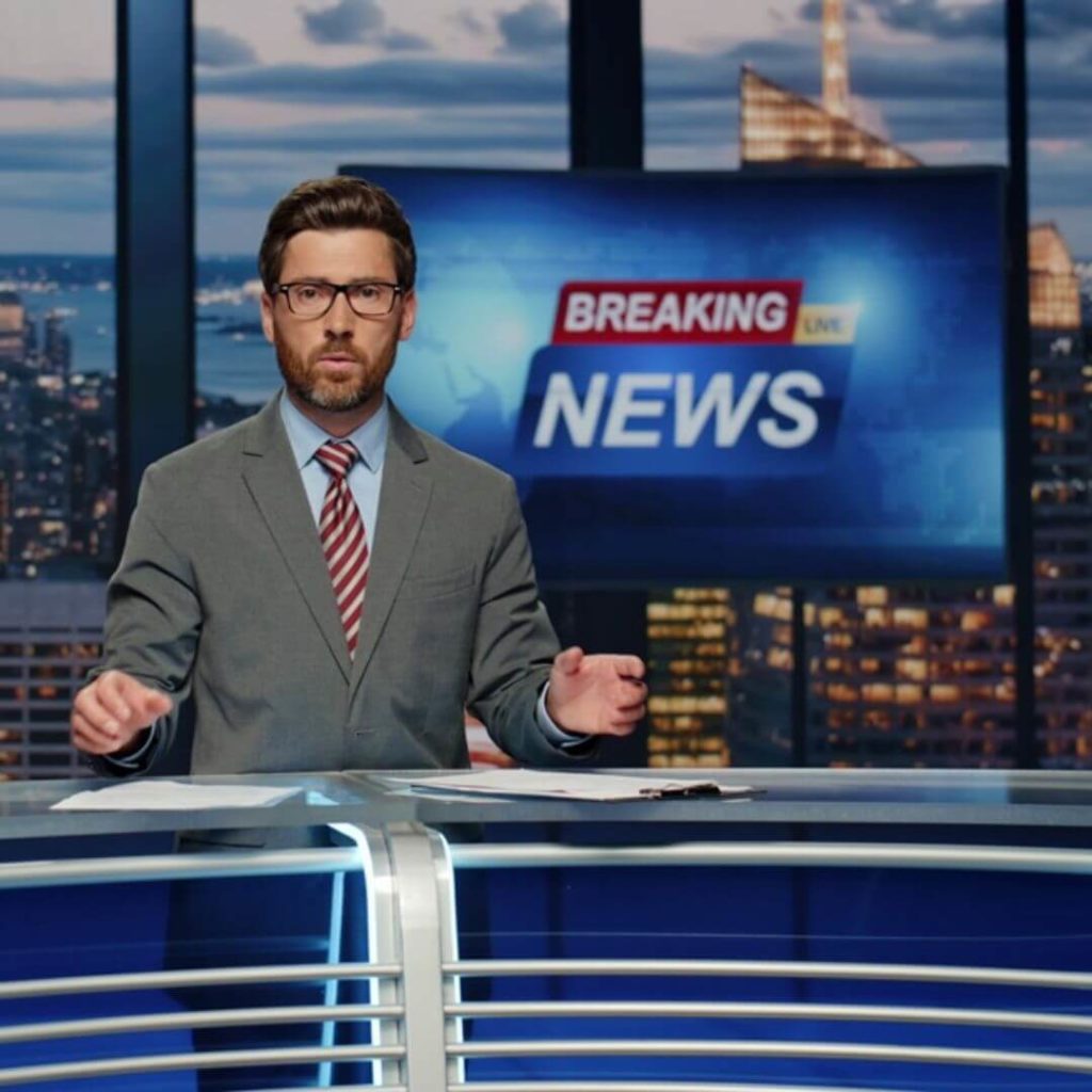 News presenter in TV studio delivering breaking news – broadcast production and media industry example