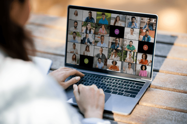 Content Creators – person attending an online video meeting with multiple participants on laptop screen