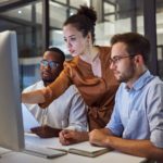 two people looking at a computer screen in the office ready to accelerate their cloud journey with AWS MAP
