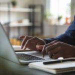 a photo of a man typing on a keyboard