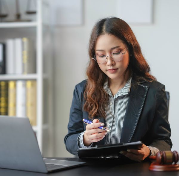 Software development consultancy - Legal tech card_ Focused lawyer reviewing legal documents and preparing for a court case in her office.