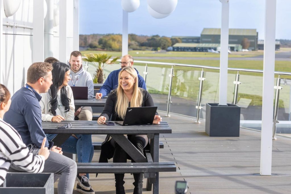 The Spyrosoft team of experts for software development in London, working in an office with an outdoor terrace.
