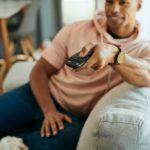 A man sitting on a couch enjoying media and entertainment