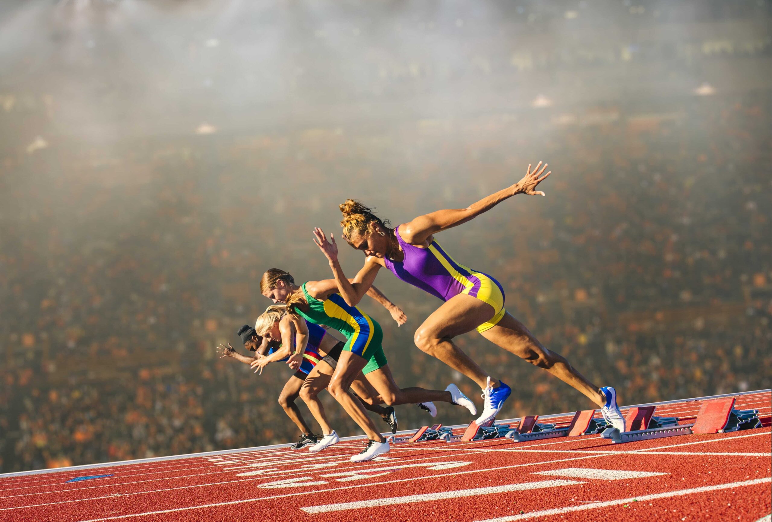 Female athletes starting a sprint race in a stadium – example of sports streaming capturing live athletic events and dynamic moments