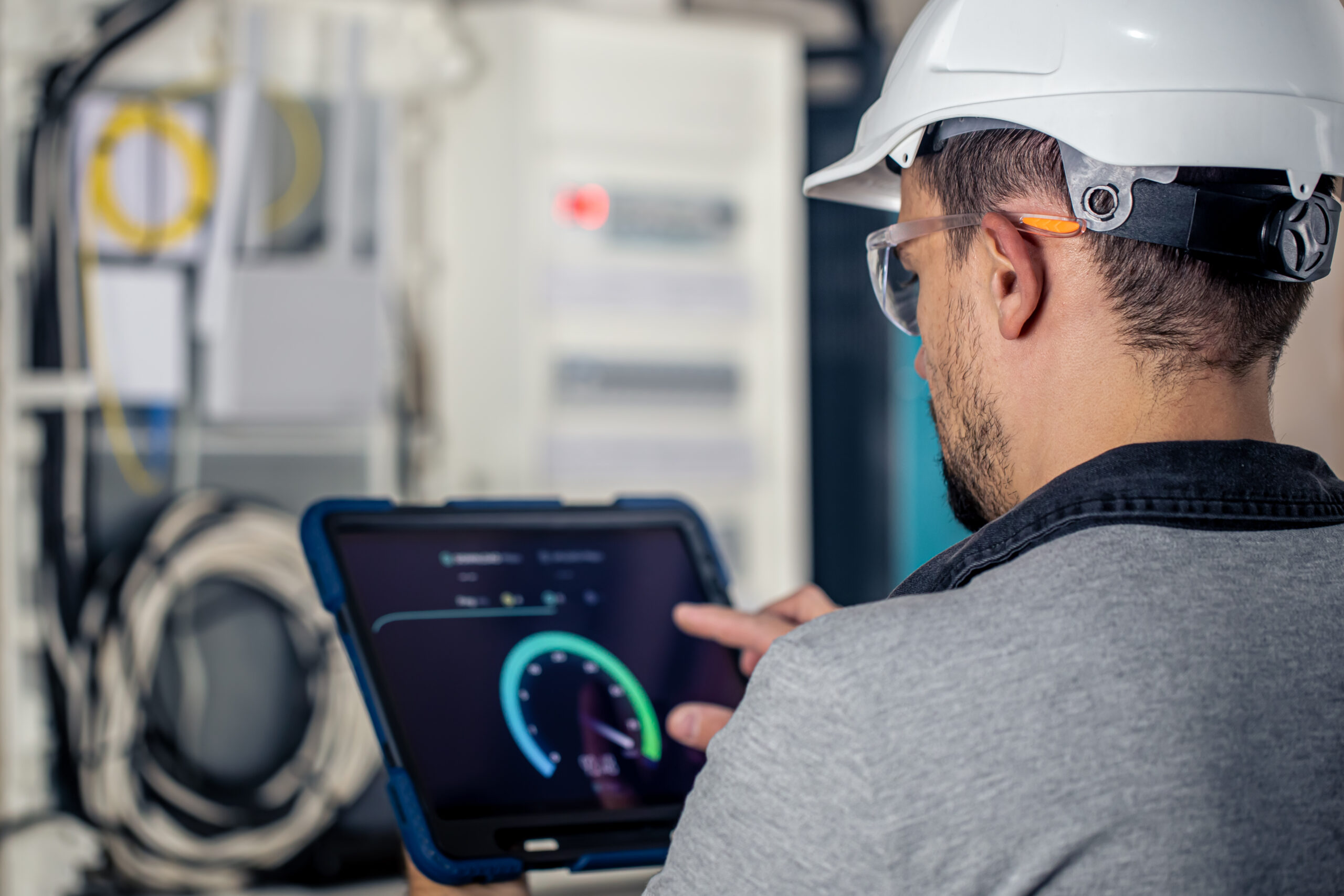 Man, an electrical technician working in a switchboard with fuses. Installation and connection of electrical equipment for Industry 4.0.