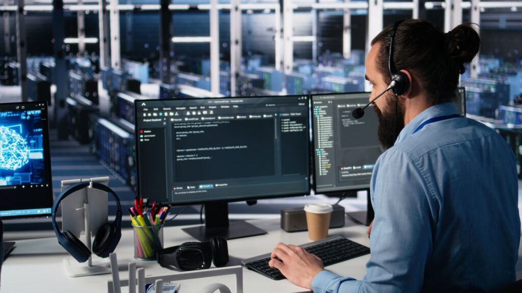 Customer support. AI assisted software development. Engineer wearing headset assisting users with AI enhanced troubleshooting