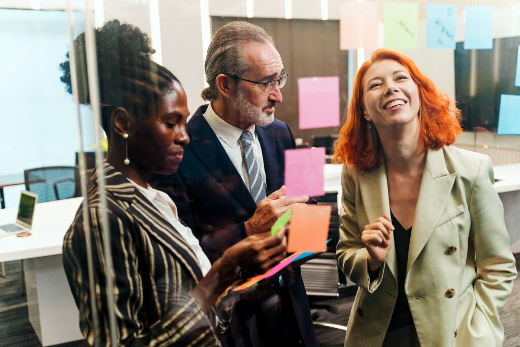 Agile consulting, Expert Advice. Team of experts collaborates in modern office, brainstorming with sticky notes on glass wall