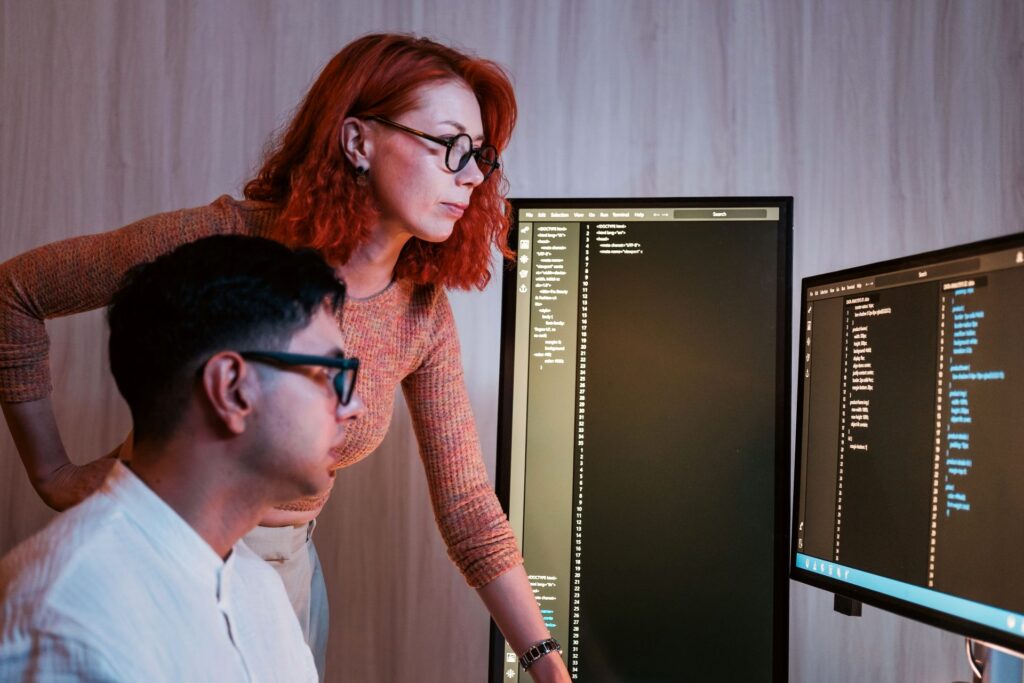 Agile consulting, Leadership support in analysing code on dual monitors in a modern office,