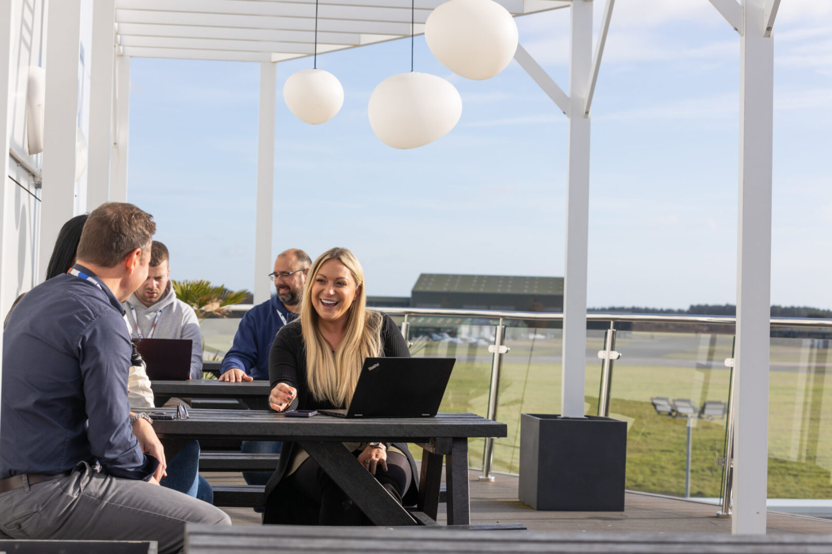Srosoft employees in Bournemouth spend their lunch break outside on a sunny but windy day.
