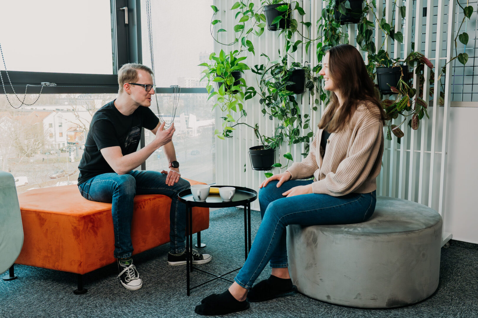 A woman and a man, both Spyrosoft employees, talk to each other in a chill room.