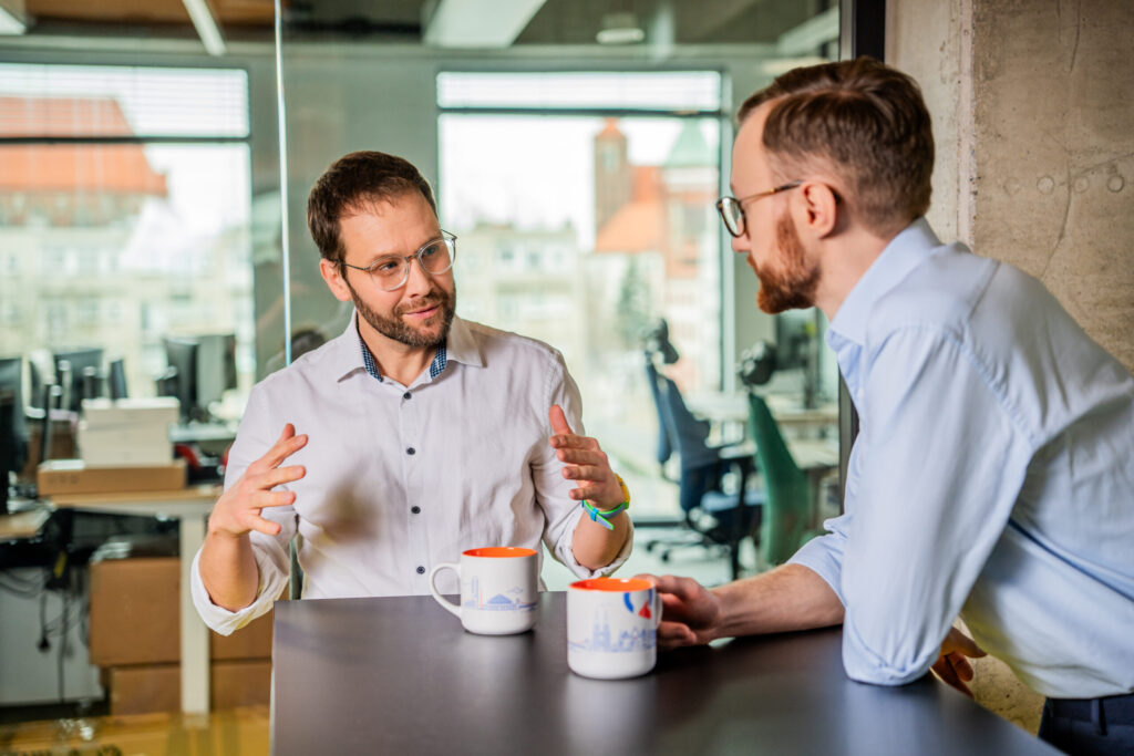 Two men are talking in the kitchen of Spyrosoft's Warsaw office.
