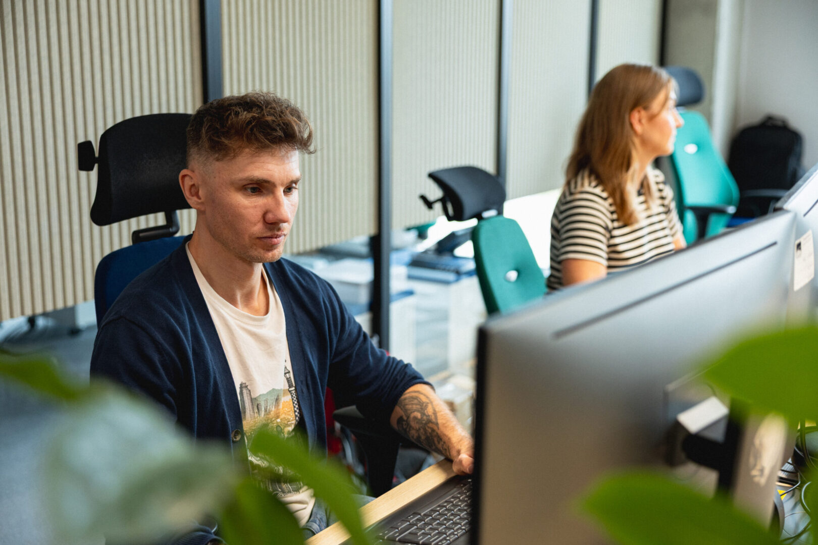 A woman and a man work on a computer in the Spyrosoft office in Wroclaw