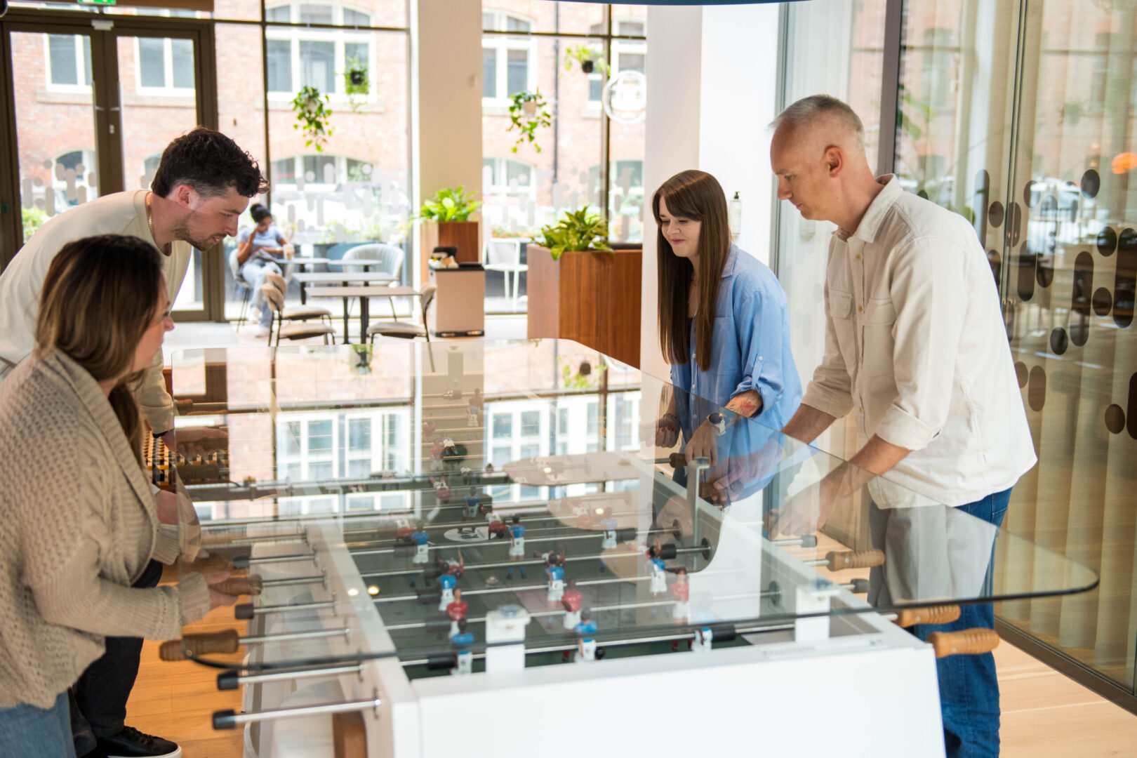A group of Spyrosoft employees in Manchester play table football