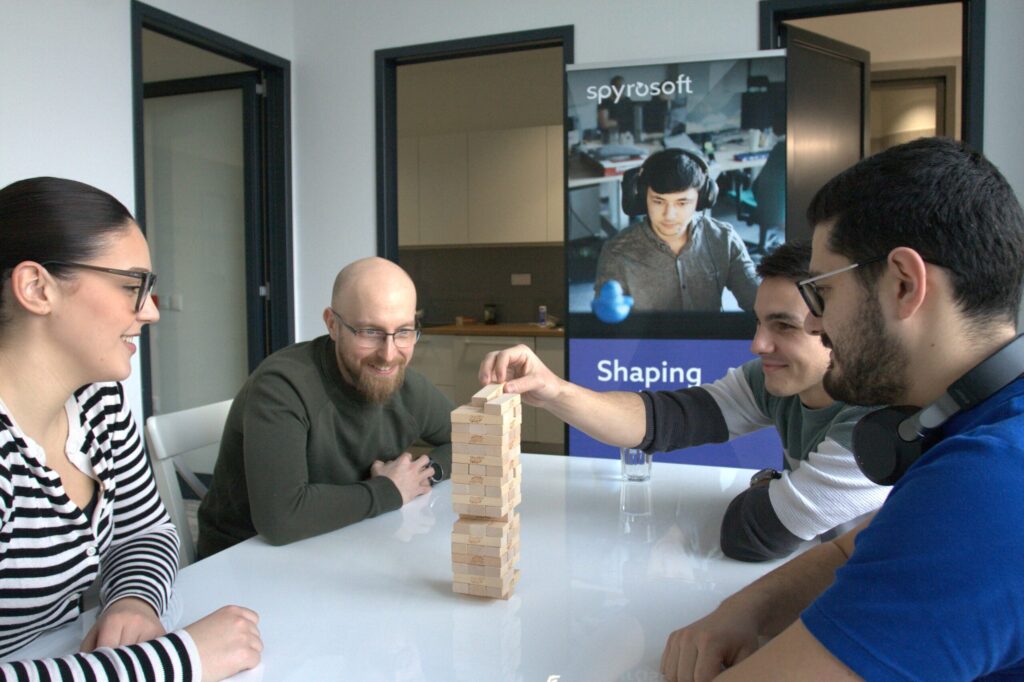 A group of Spyrosoft employees bond over a game, at the office in Osijek