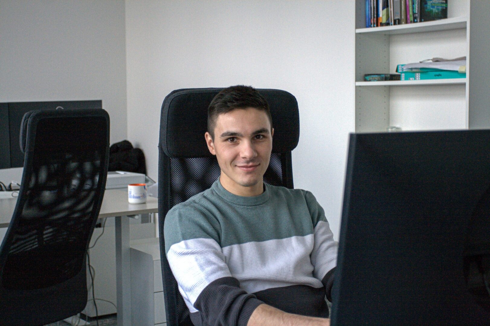 A young man works at a computer in the Spyrosoft office in Osijek