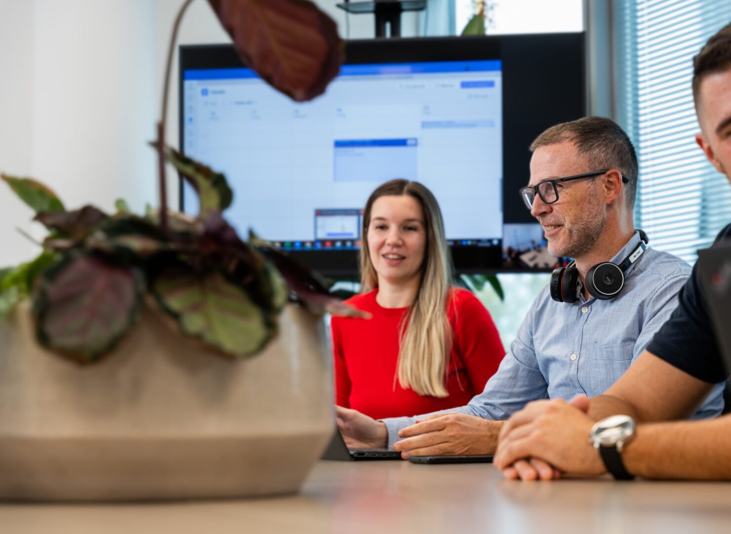 Three people are sitting at a conference table in Spyrosofyt's Zagreb office. They are a young woman and two men.