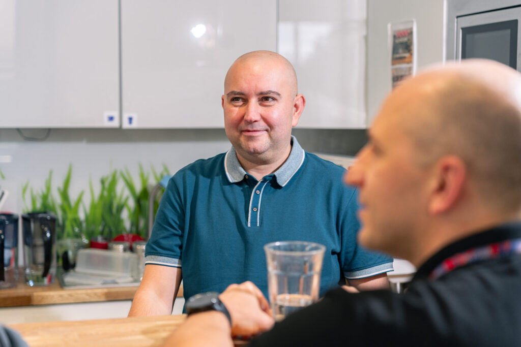 Two men talk to each other in the kitchen area of ​​the Spyrosoft Synergy office in Szczecin.